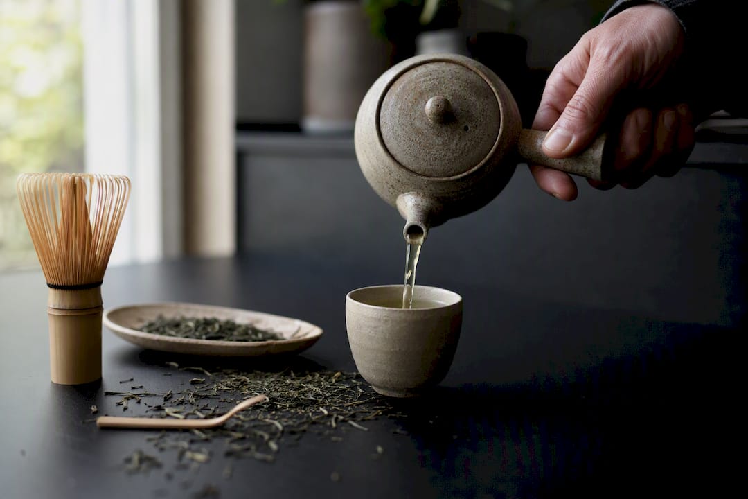 Grønn te blir servert fra en tradisjonell japansk kyusu-kanne.