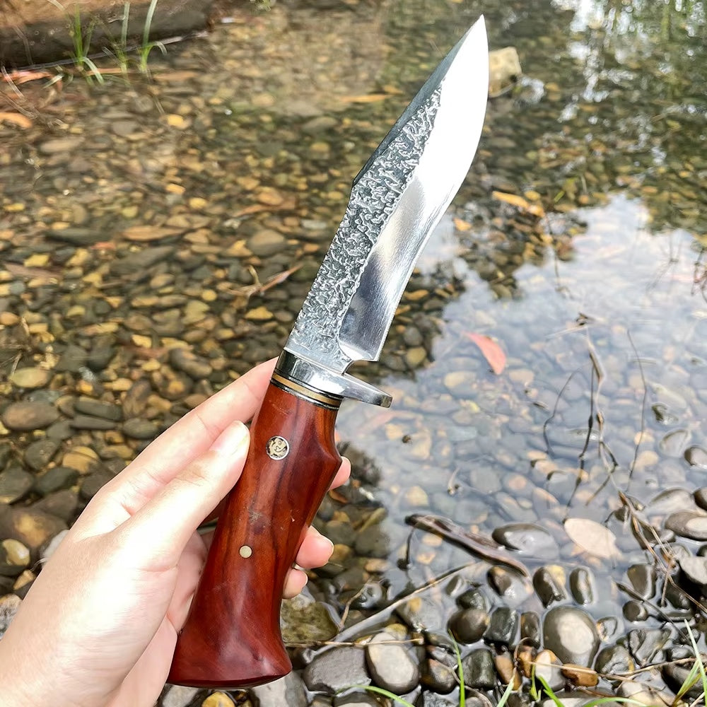 Senko turkniv med blankt blad og trehåndtak ved en bekk
